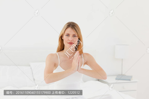 女人在她的床上練習瑜伽