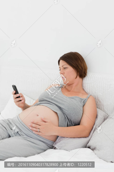 懷孕的女人看著她的手機(jī)