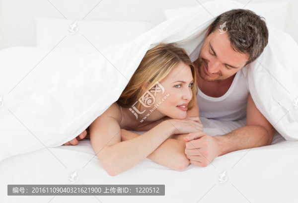 可愛的一對在他們的床上擁抱