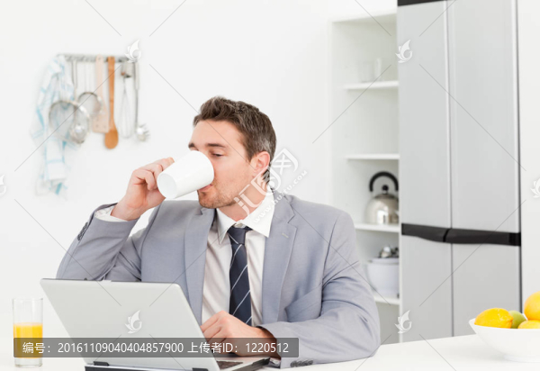 商人一邊喝一邊看著他的筆記本電腦