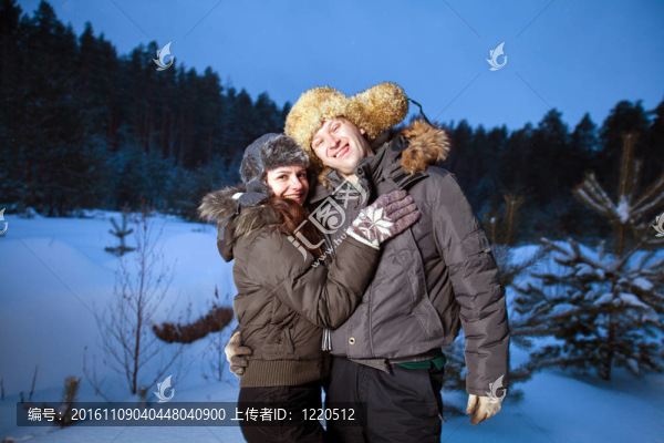在冬季森林里的美麗的夫婦