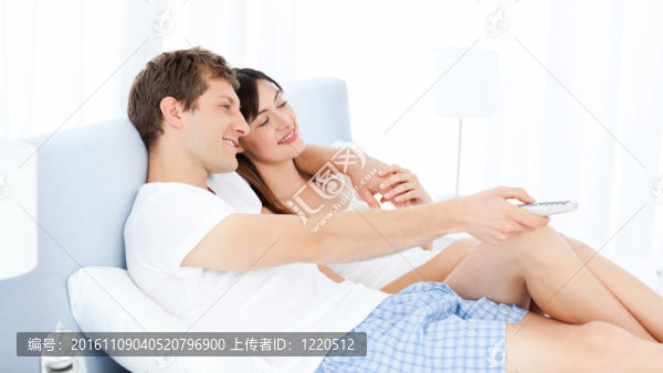 微笑的夫妻在家看電視