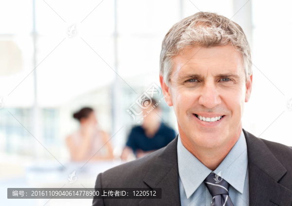 商人看著相機(jī)，而他們的團(tuán)隊(duì)正在工作