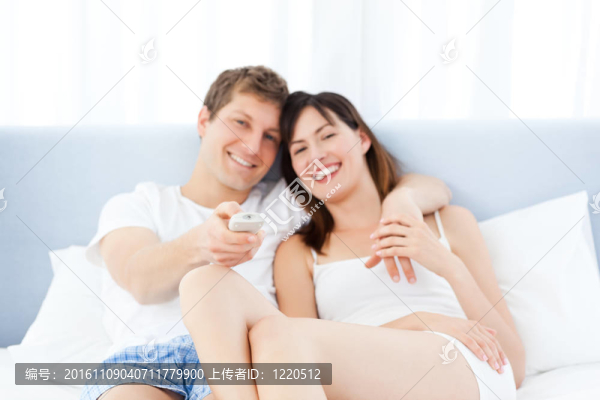 微笑的夫妻在家看電視