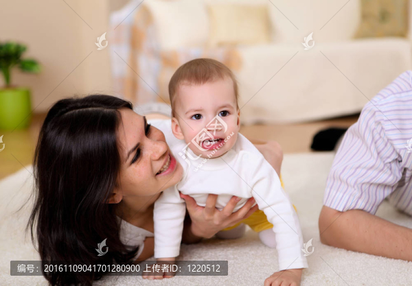 年輕的家庭在家里玩一個嬰兒