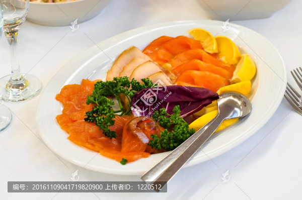 餐桌上帶熏魚的餐具；晚餐餐具；白餐巾；選擇性聚焦。