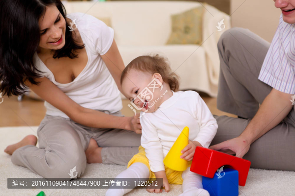年輕的家庭在家里玩一個(gè)嬰兒
