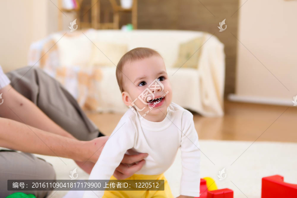 年輕的家庭在家里玩一個(gè)嬰兒