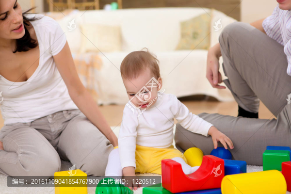 年輕的家庭在家里玩一個嬰兒