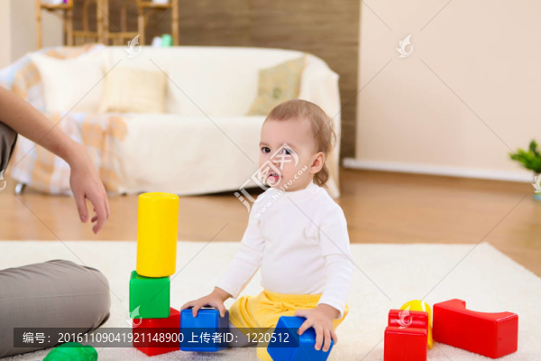 年輕的家庭在家里玩一個嬰兒