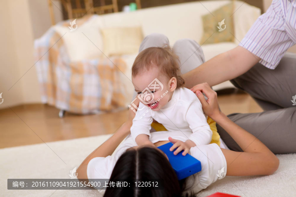 年輕的家庭在家里玩一個(gè)嬰兒