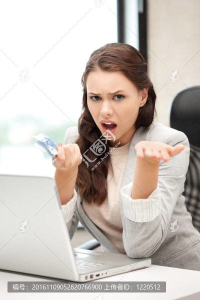 不幸的女人用電腦和歐元現(xiàn)金
