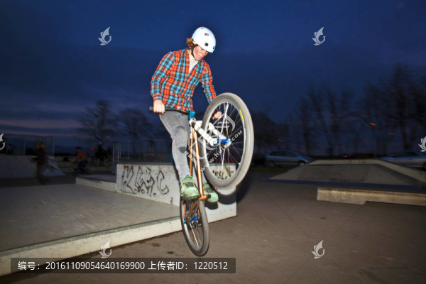 男孩在他的越野車跳躍在滑板公園的夜晚