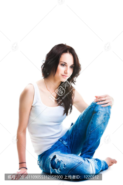 穿著藍色牛仔褲的漂亮女人坐在白色地板上