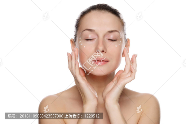 美麗性感的女人在眼部附近涂抹化妝品霜