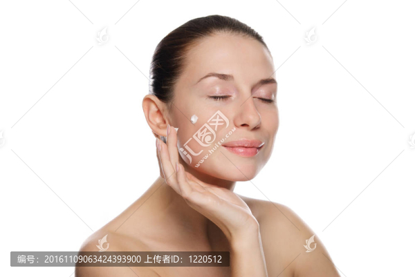 美麗性感的女人在眼部附近涂抹化妝品霜