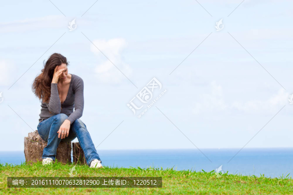 沮喪沮喪的年輕女子坐在外面