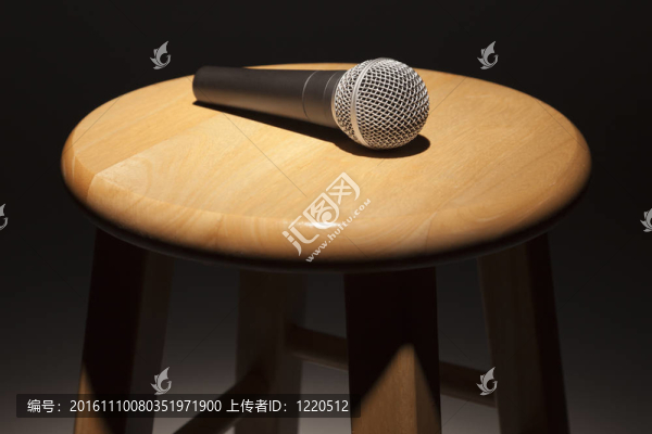 在聚光燈下木制凳子上放置麥克風(fēng)