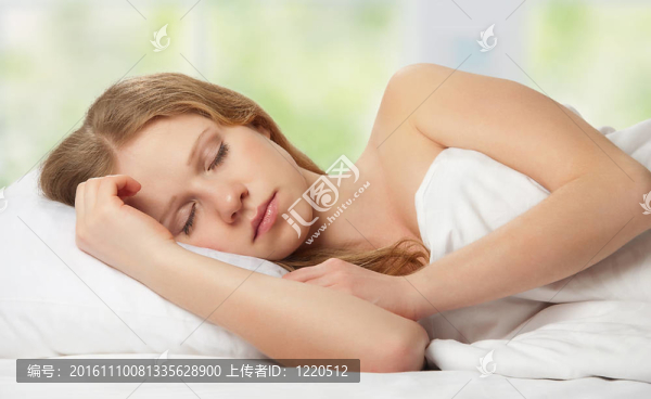 美麗的年輕女人在床上睡覺