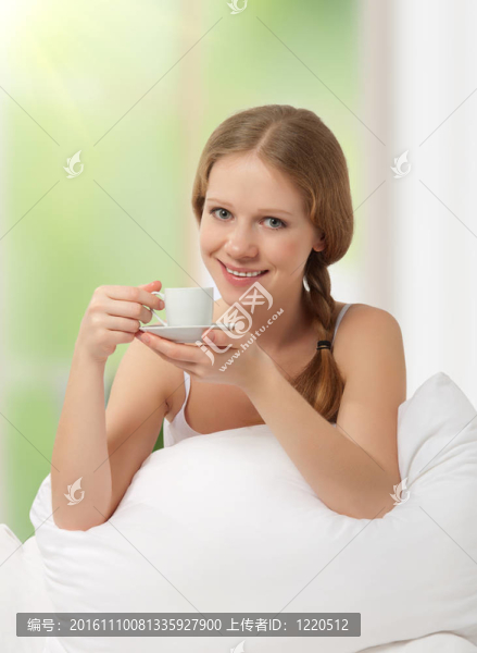 美麗的女孩在床上喝咖啡