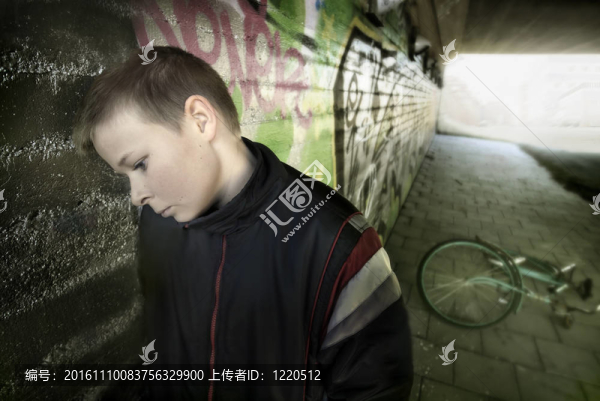 不安的男孩靠在墻上