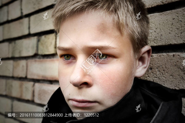 不安的男孩靠在墻上
