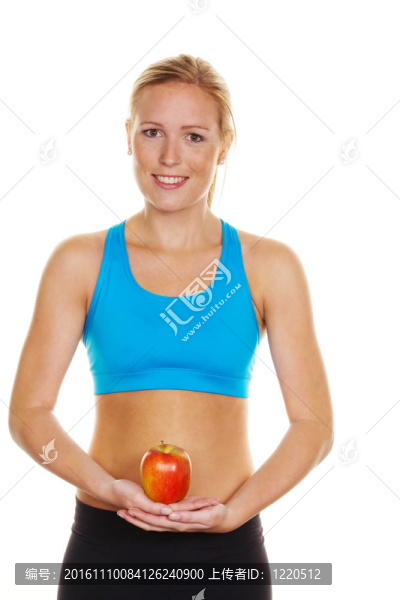 一個穿著運動服的年輕女子手里拿著一個蘋果