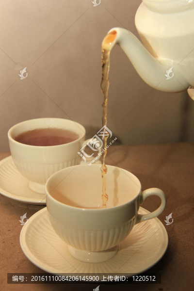 在經(jīng)典的白色茶杯倒茶