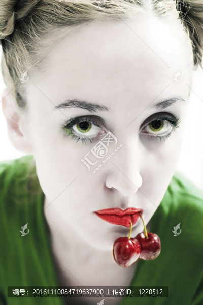 漂亮的綠眼睛女人嘴里有櫻桃