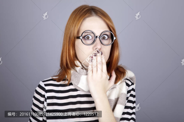 驚訝的紅發(fā)女孩戴著眼鏡和圍巾。