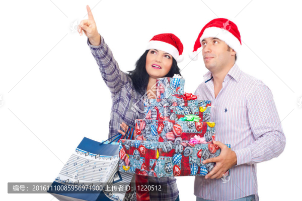幸福的夫婦拿著圣誕禮物和指向