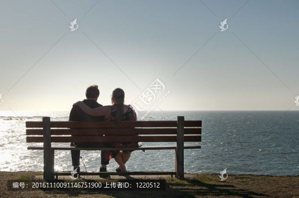 兩個(gè)在海洋視圖長(zhǎng)椅上放松的夫婦