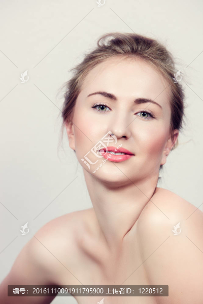 美麗的女人與自然化妝的綠色眼睛和珊瑚的嘴唇上糖果粉紅色的背景