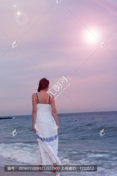 夕陽中的一個女孩在海邊散步