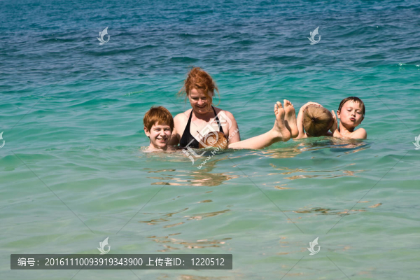 家庭在海邊玩椰子在美麗的海灘上