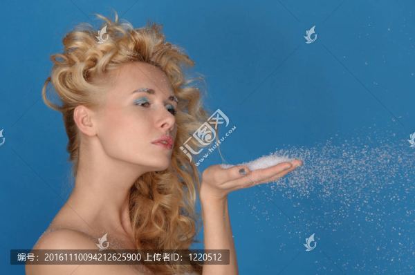 美麗的女人用手吹雪