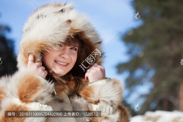 在寒冷的公園在毛皮大衣的女孩