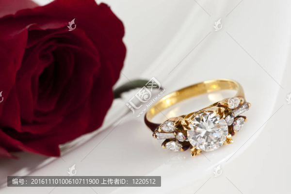 白色背景上的金色鉆戒和玫瑰