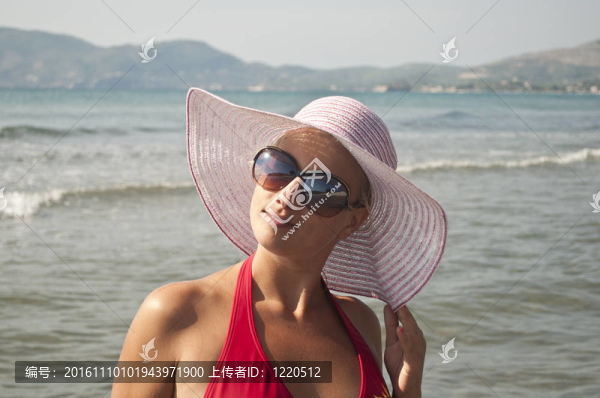 美麗的女人與草帽冒充海灘附近