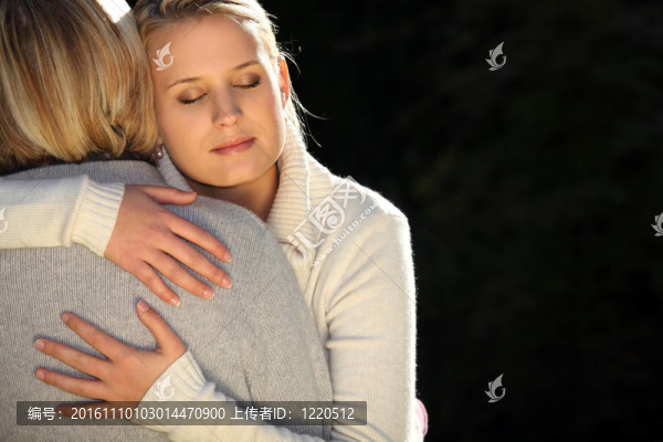 一位母親和她十幾歲的女兒擁抱。