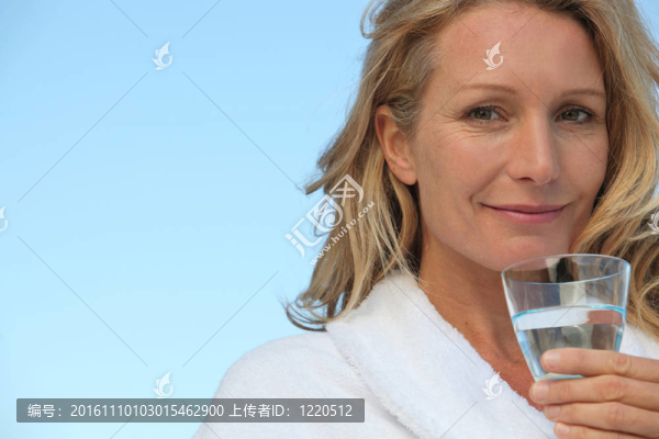 迷人的金發(fā)女人沒有化妝和喝一杯水
