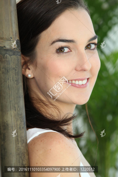 一個女人的臉靠近一個大竹子