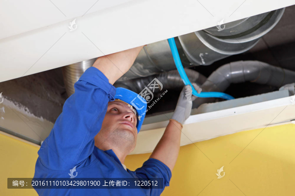 空氣管下放置藍色管道的工人