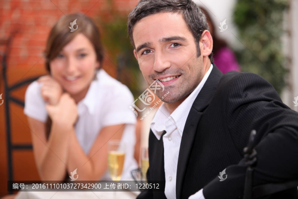 一個40歲的男人和一個16歲的女孩在餐廳桌子上放著汽酒