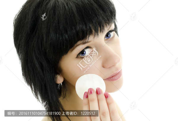 特寫的婦女用棉簽清洗她的臉。白色孤立。