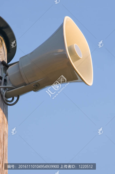 藍天上空的電線桿上的灰色塑料喇叭喇叭