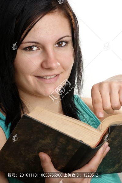 一個年輕的女人在一本書上看書