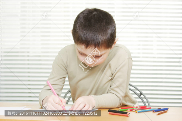 在桌上用蠟筆畫的可愛男孩