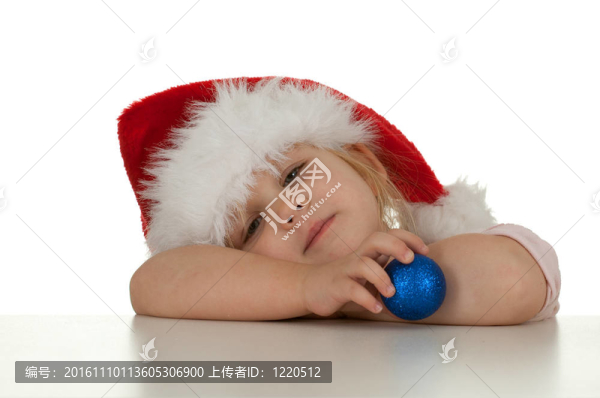疲憊的圣誕女孩在紅色Santa帽子與玻璃球