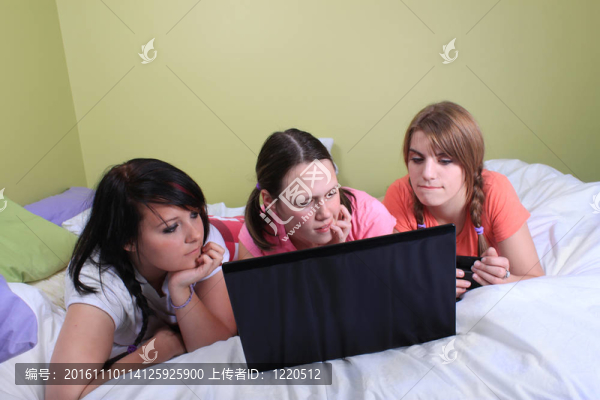 女孩在床上使用筆記本電腦